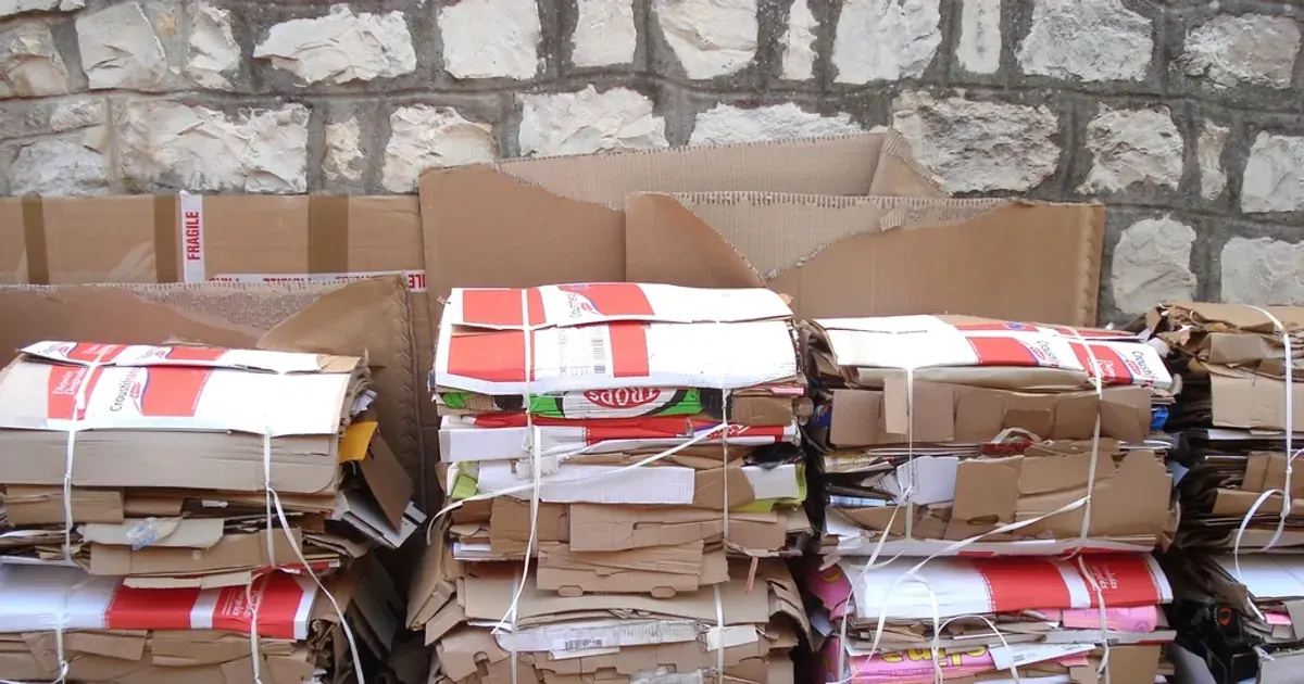 Pile of flattened and stacked cardboard boxes against a wall