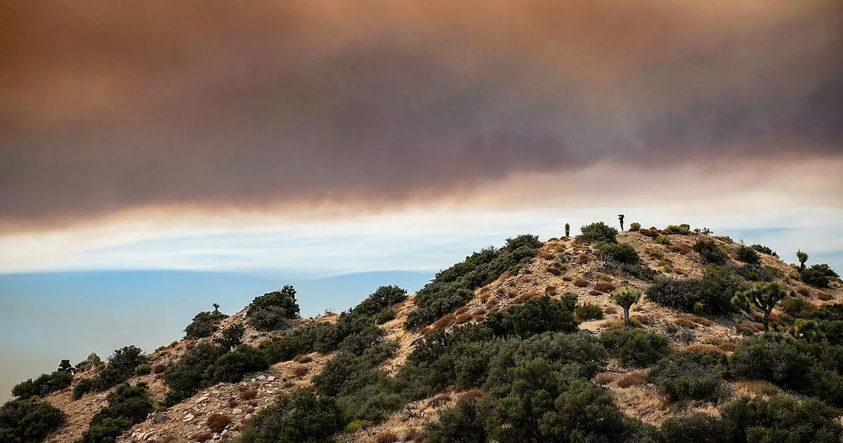 Smoke rising over dry desert hills in Southern California