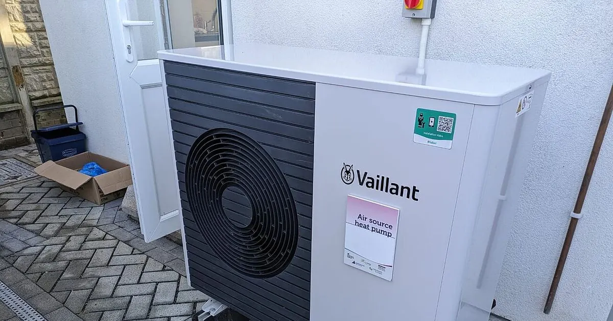 Outdoor air source heat pump unit installed beside a house