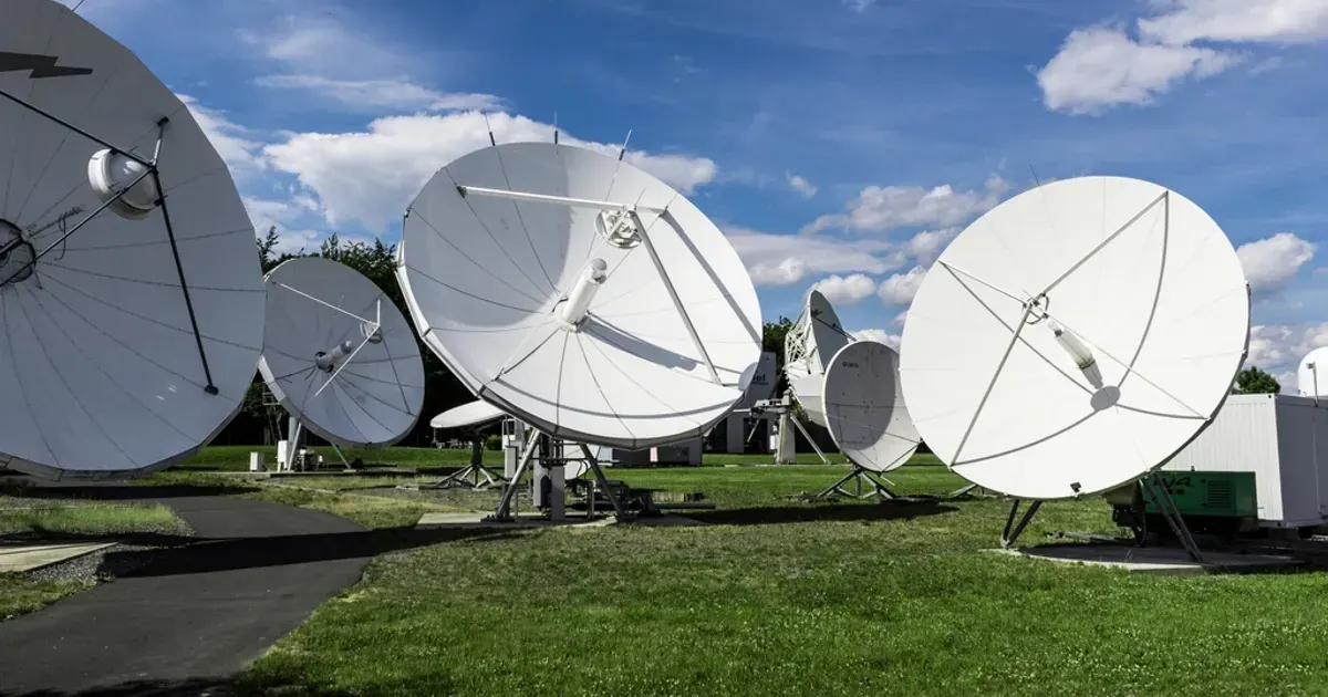 Large white satellite dish antennas pointed at the sky for space communications