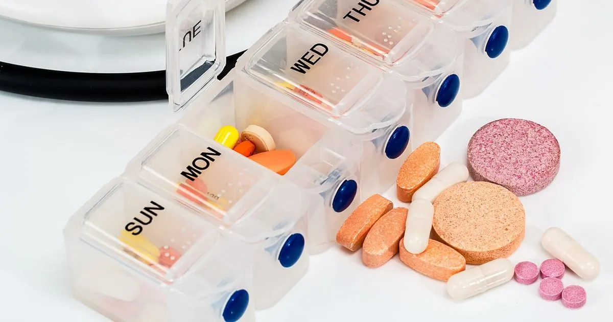 A weekly pill organizer filled with tablets and capsules