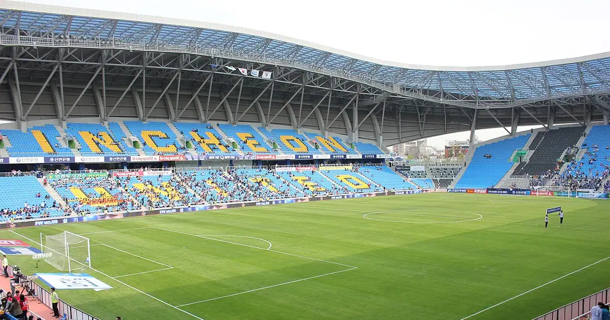 Football stadium with green pitch and empty seats
