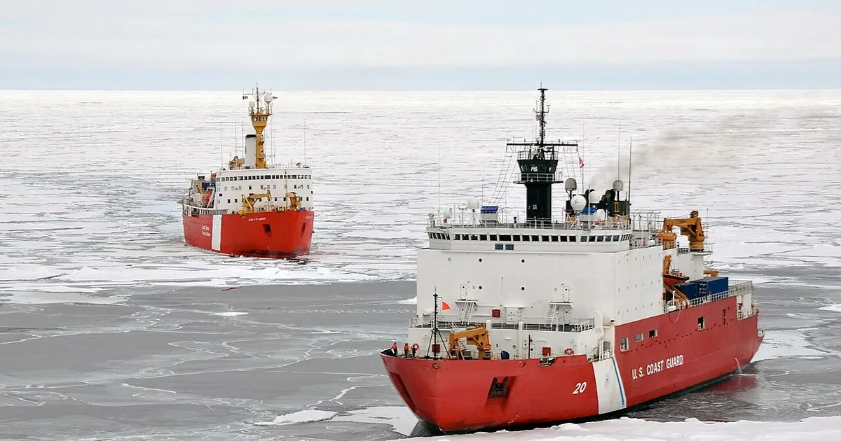 Two red-and-white icebreaker ships moving through sea ice in the Arctic Ocean