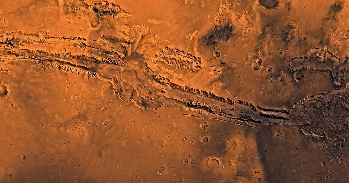 Orbital view of the red surface of Mars with the Valles Marineris canyon