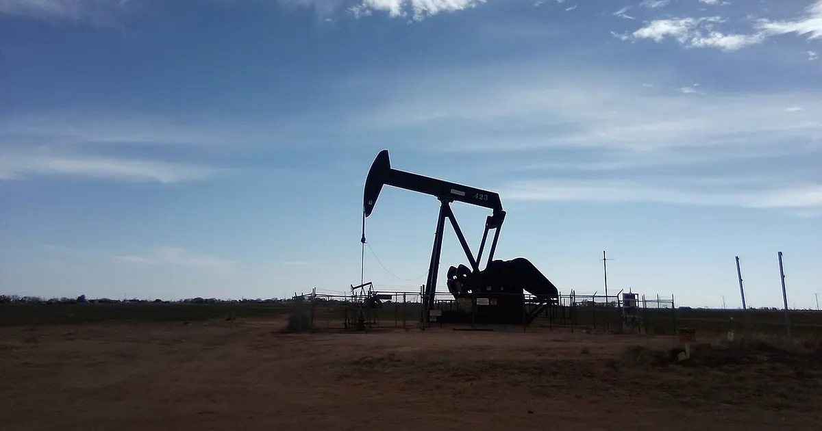 Oil pump jack silhouette against a cloudy sky