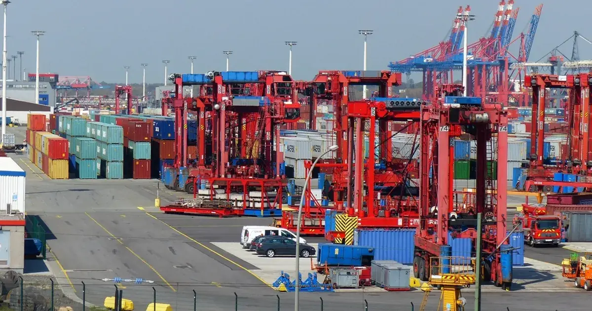 Container terminal with stacked shipping containers and red cargo cranes