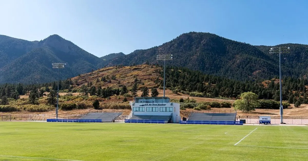 Empty soccer stadium seating overlooking a green pitch