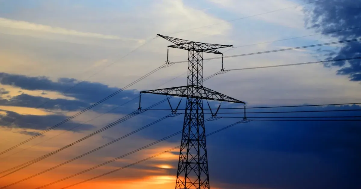 Electric transmission pylons and power lines under cloudy sky