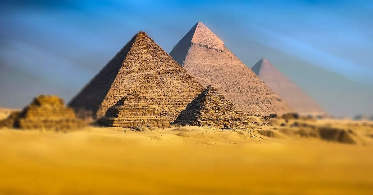 Pyramids of Giza rising above desert sand in Egypt