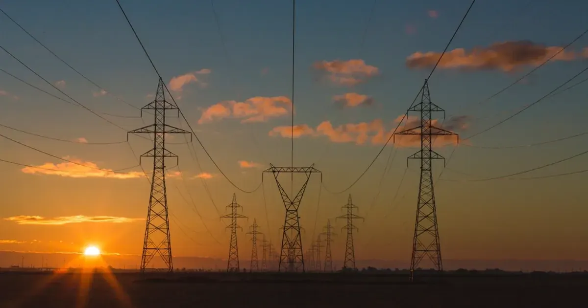Electricity pylons and power lines at sunset