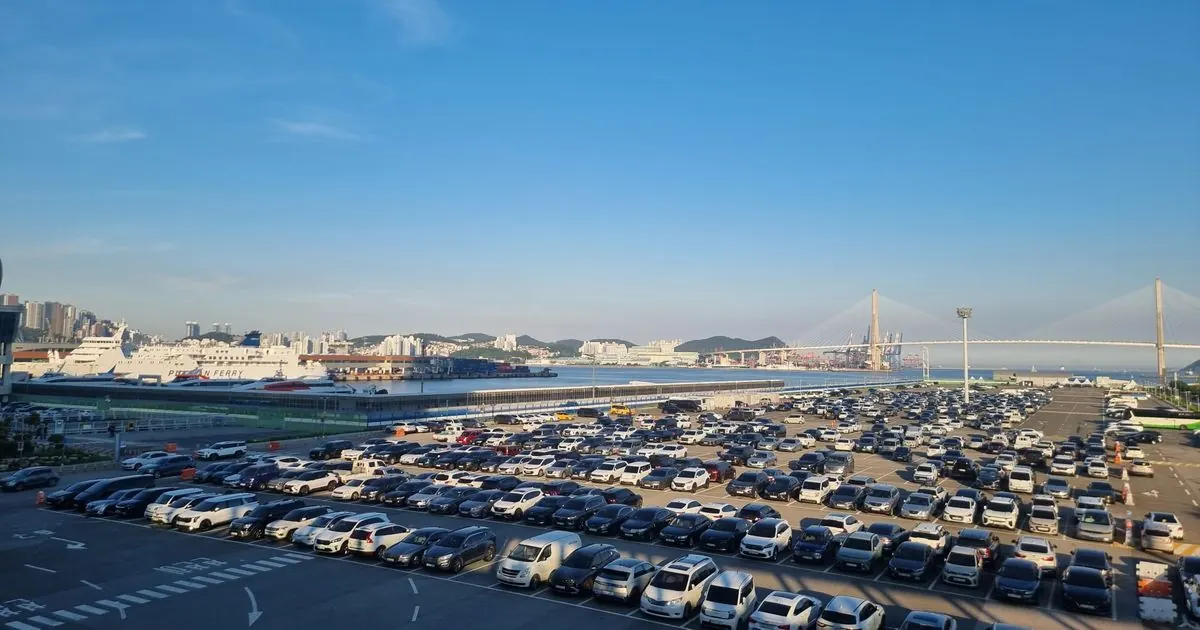 Busan's passenger ferry terminal with ships docked and a cable-stayed bridge across the bay