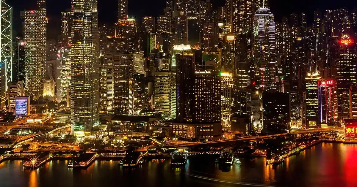 Skyscrapers lit up at night along Victoria Harbour in Hong Kong