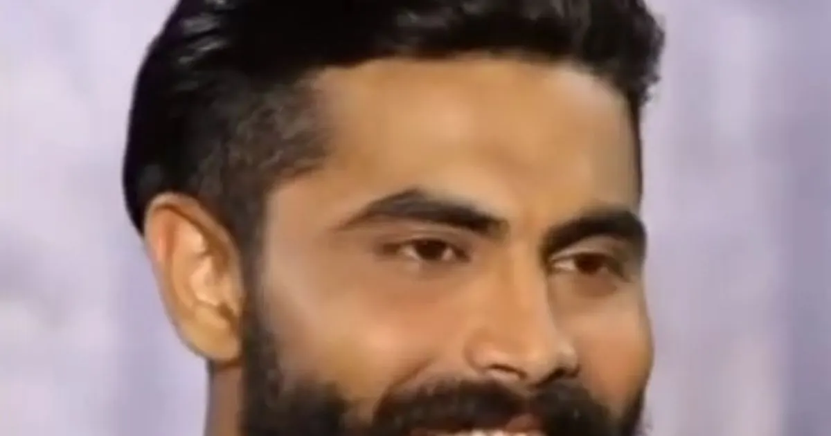 Portrait of Ravindra Jadeja smiling in a green polo shirt