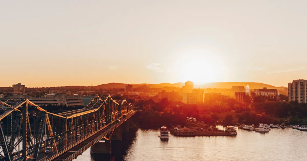 Sunset over the Ottawa River with the Alexandra Bridge linking Ottawa and Gatineau and boats at a marina