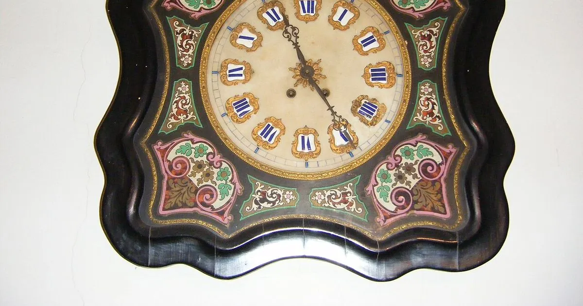 Round analog wall clock mounted on a plain wall