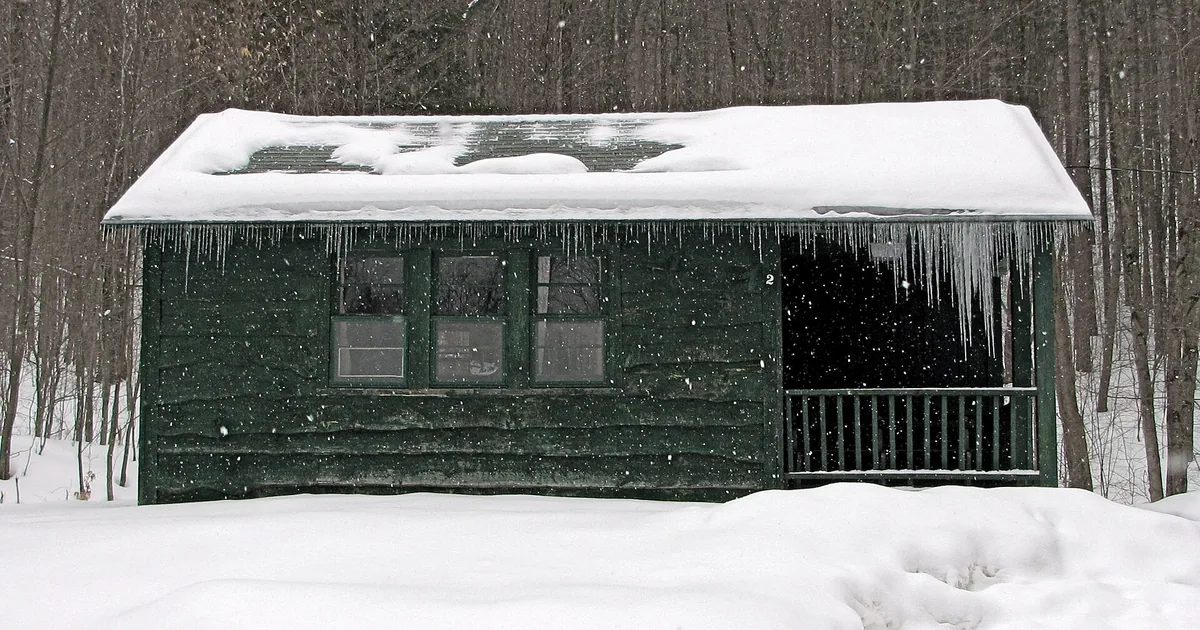 A wooden cabin surrounded by snow