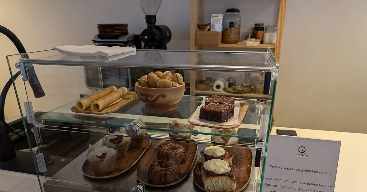 Pastries and baked goods lined up in a glass cafe display case