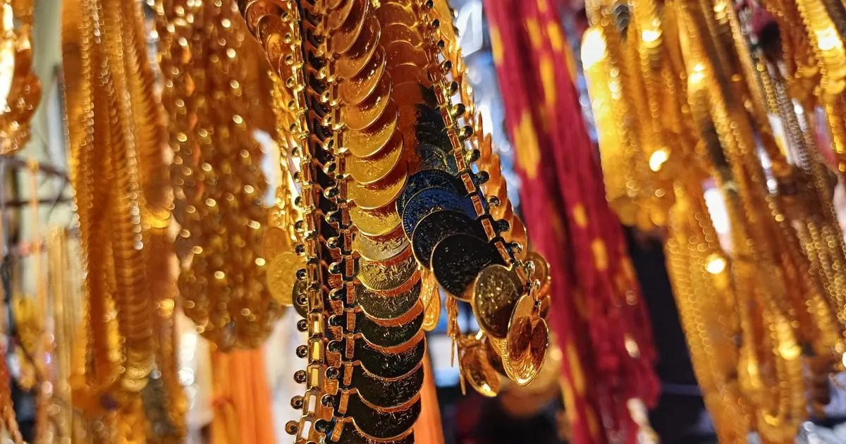 Gold coin necklaces and chains hanging on display in a jewellery shop