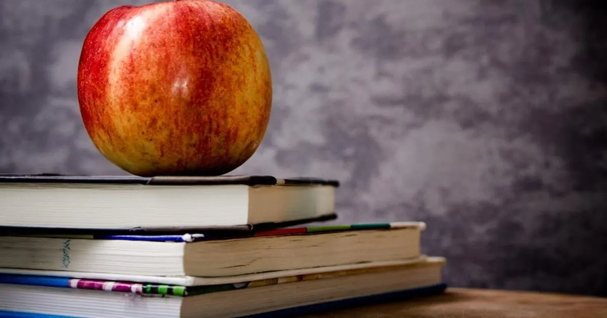 Stack of textbooks on a wooden desk