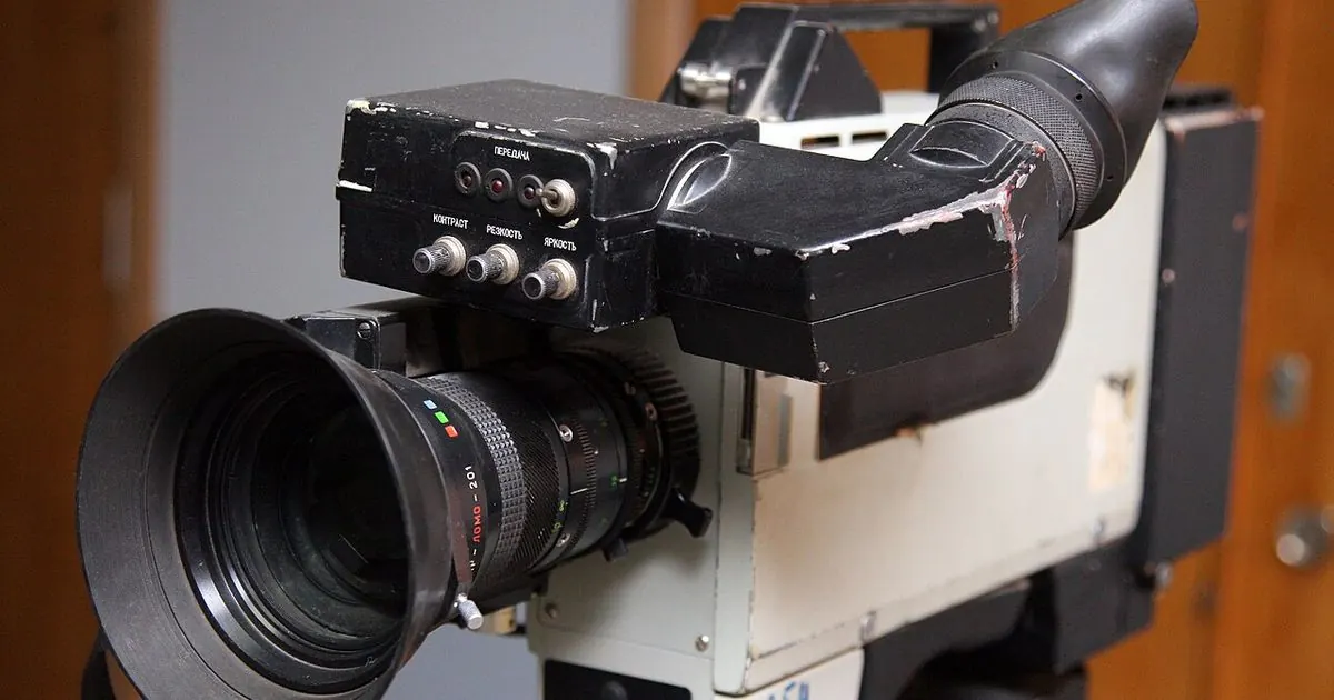 A vintage professional video camera with a large zoom lens and viewfinder