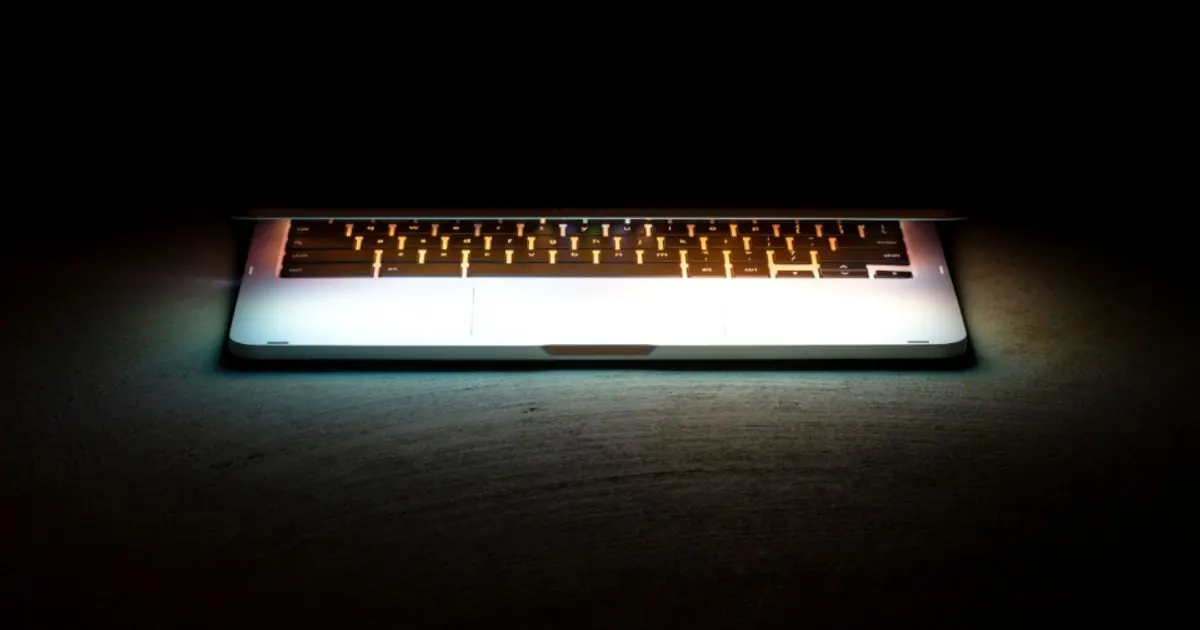 A half-open laptop with a glowing keyboard