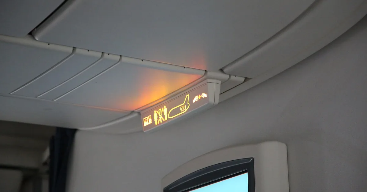 A carry-on bag inside an airplane overhead bin