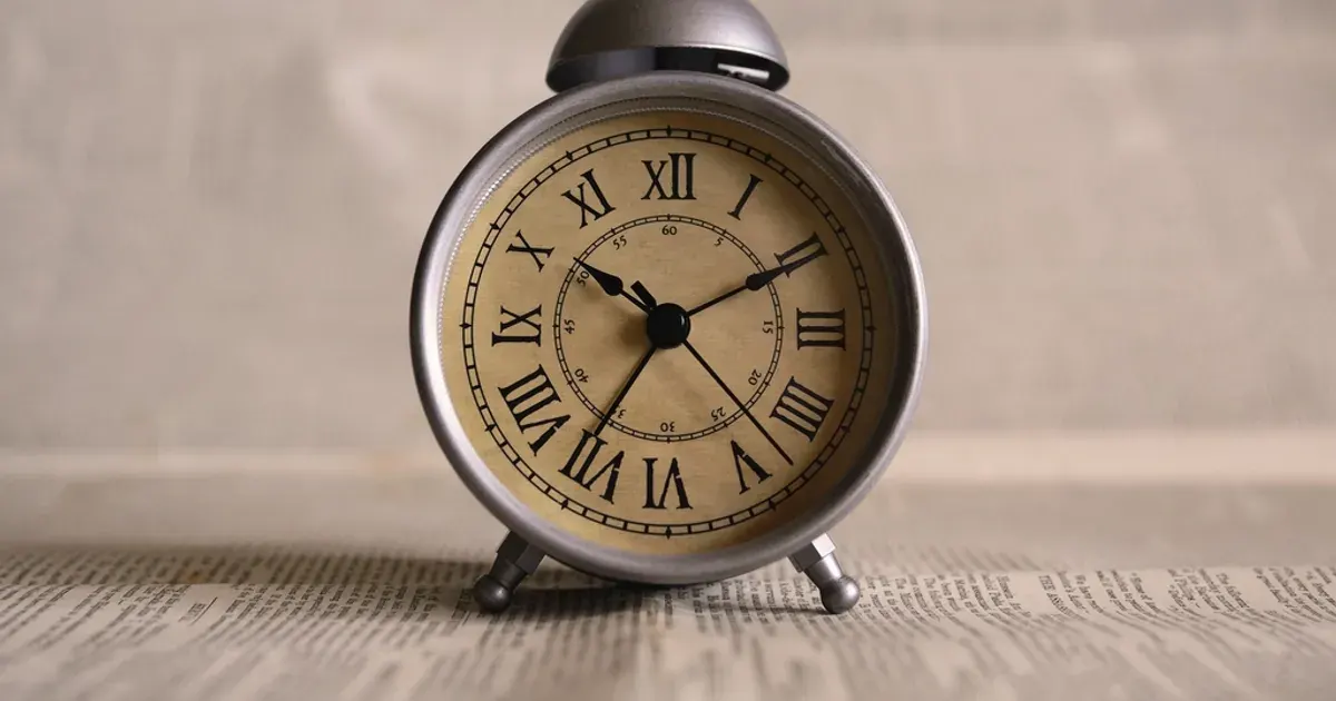 Vintage silver alarm clock with Roman numerals on its face