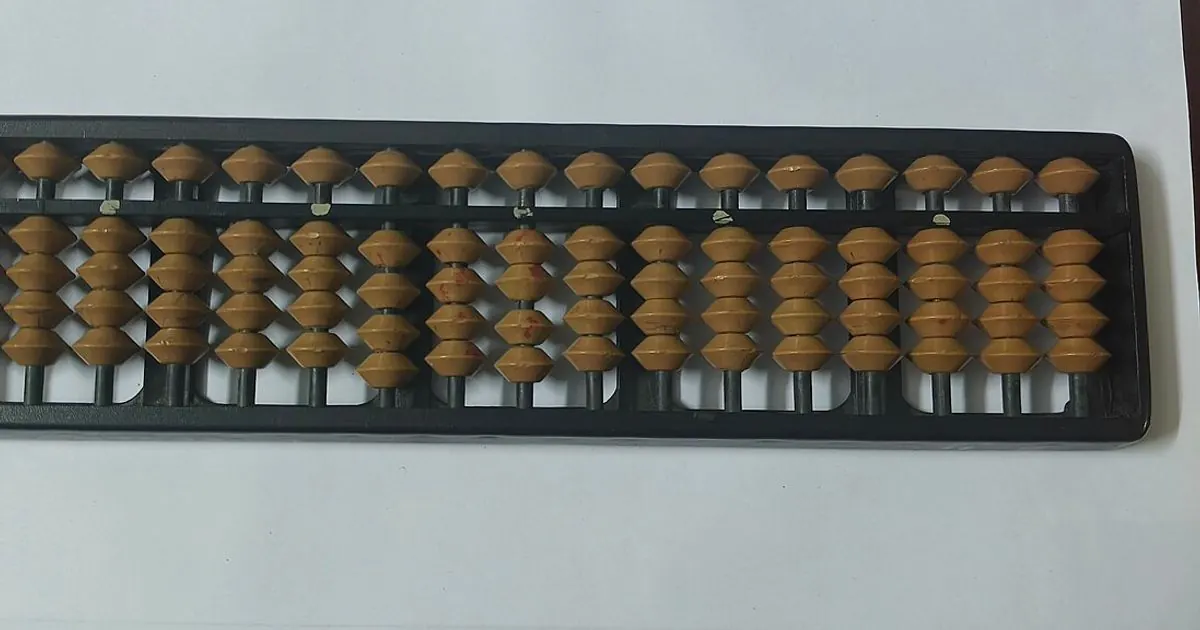 A black-framed abacus with rows of light brown counting beads, a classic tool for learning place value and rounding