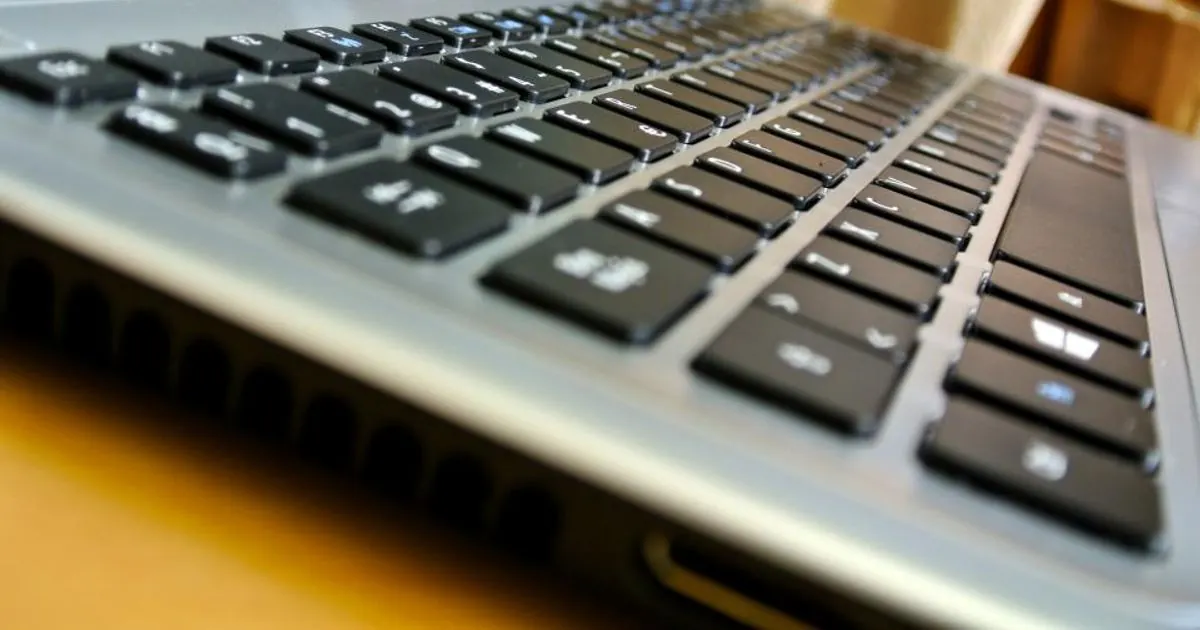 Close-up of a laptop keyboard on a wooden desk